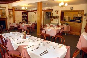 赫里福德霍普比奈住宿加早餐旅馆的餐厅配有桌椅和粉红色的桌布