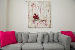 雅典Cosy apartment in Glyfada center的一张带粉红色枕头的沙发以及墙上的绘画