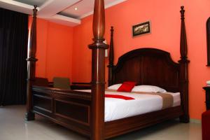万隆赛尔森巴胡里红门旅馆的一间卧室配有一张橙色墙壁的床