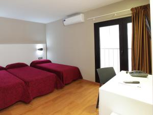 贝尼多姆阿拉美达酒店的一间卧室设有两张床、一张桌子和一个窗口。