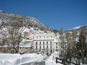 维勒塔巴雷亚Il rifugio nel parco的一座雪覆盖的城市,其背景是一座建筑