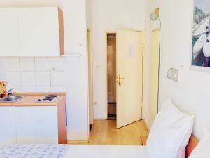 卡什泰拉Apartments Ruza的客房设有厨房、水槽和床。