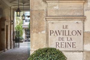 巴黎Le Pavillon de la Reine & Spa的读到雷恩凉亭的建筑物上的标志