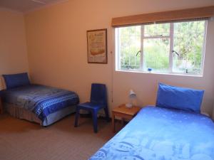 滨海肯顿Paulyn Place的一间卧室设有两张床、一个窗口和椅子
