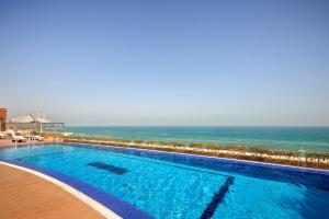科威特科威特萨菲尔菲尼亚斯酒店的一座背景海洋的游泳池