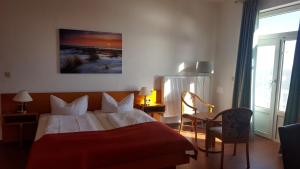 威廉港Hotel Seerose的酒店客房,配有一张带红色毯子的床