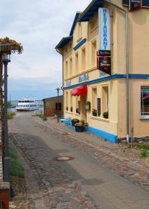 吕根岛上的维克Hotel-Pension Zur Mole的街道上的建筑,有船在后面