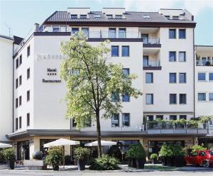 威斯巴登Trüffel Hotel的前面有一棵树的白色大建筑
