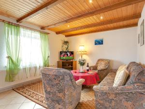 巴贝Ferienhaus in Baabe D 092.049的客厅配有两把椅子、一张桌子和电视