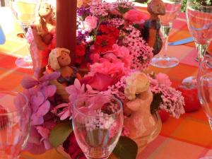 Saint-Aubin-le-Monial圣欧班酒店的一张桌子,上面放着鲜花和泰迪熊,还有酒杯