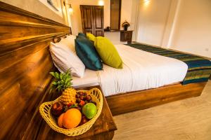 努沃勒埃利耶四季酒店 - 努沃勒埃利耶的一间卧室配有一张带水果篮的床