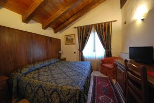 尚波吕克贝立维酒店的一间卧室配有一张床、一台电视和一把椅子