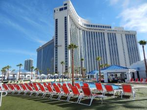 拉斯维加斯Westgate Las Vegas Resort and Casino的酒店前方设有一组椅子和游泳池