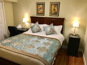温哥华湾景度假屋的一间卧室配有一张带两盏灯和两张桌子的床。