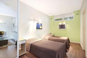 悉尼邦迪海滩终极公寓 的酒店客房,设有两张床和镜子