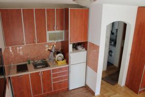 贝尔格莱德Calm Apartment的一个带木制橱柜和水槽的小厨房