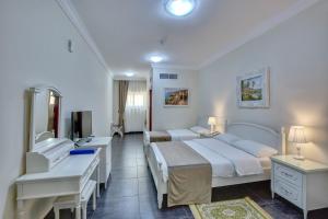 沙迦Royal Hotel的酒店客房设有两张床和电视。