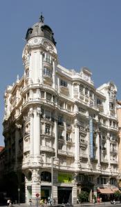 马德里大西洋酒店的一座白色的大建筑,上面有钟