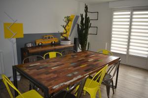 RullyRullyoloft的一间带木桌和黄色椅子的用餐室
