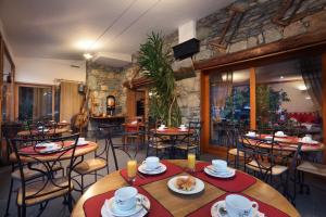圣莫里斯堡奥坦蒂克酒店的一间带桌椅和石墙的餐厅