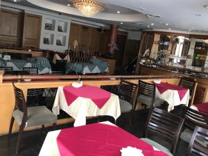 虎尾镇什叶派伊赫酒店的一间带桌椅的餐厅和一间酒吧