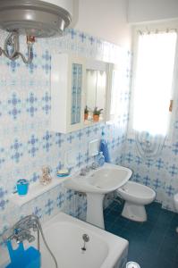 阿尔玛·迪·塔吉亚San Michele的蓝色和白色的浴室设有水槽和卫生间