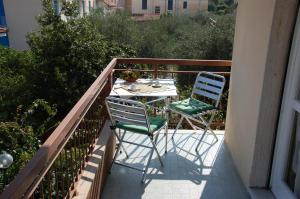 阿尔玛·迪·塔吉亚San Michele的阳台配有2把椅子和1张桌子