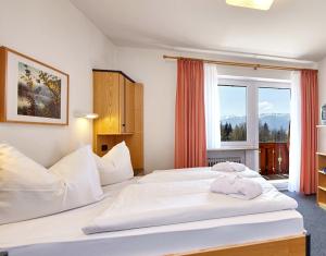 绍尔格鲁布AURA-HOTEL Saulgrub的酒店客房设有两张床和窗户。