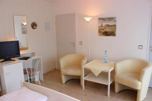 巴德茨维什安嘉里拉美酒店的小房间设有两把椅子、一张桌子和电视