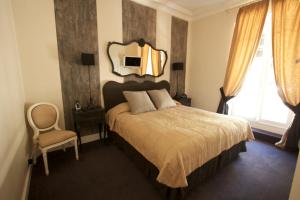 卡普戴尔摩纳哥酒店的卧室配有一张壁挂镜子的床