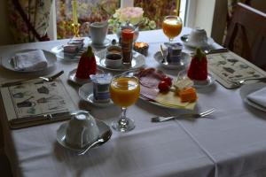 基拉尼基拉尼瓜惹住宿加早餐旅馆的一张桌子,上面有白色的桌布,上面有食物和饮料