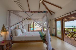 南威瓦雷雷海滩酒店的一间卧室设有一张天蓬床,享有海景