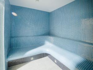 尤斯托尼莫斯基DWIE SOSNY Apartament 52的蓝色瓷砖浴室设有浴缸