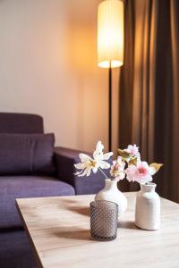 因斯布鲁克Daxburg Apartments的两只白色花瓶,桌子上放着鲜花