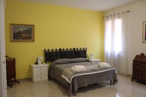 博洛尼亚Carbonara Apartment的一间卧室设有一张床和黄色的墙壁