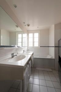 圣艾米隆克曼德里奥贝尔奇酒店的浴室配有两个盥洗盆和浴缸。