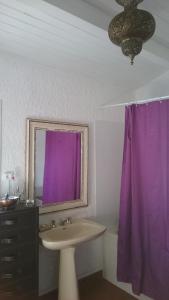 QuinsacLe Gîte的一间带水槽和紫色窗帘的浴室