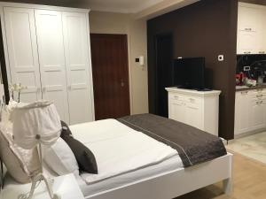 诺维萨德Lux new white apartment的卧室配有白色的床和电视。