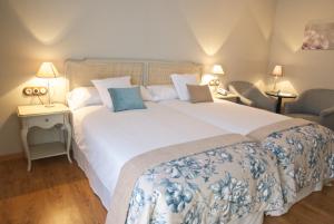 阿尔卡尼斯维拉蒙特酒店的卧室配有一张白色大床和两把椅子