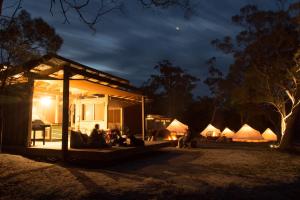 比那隆湾Bay of Fires Bush Retreat的一群人晚上坐在房子外面