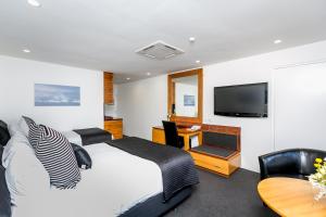 新普利茅斯Plymouth International的一间卧室配有一张床、一台电视和一张桌子