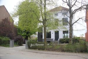 布鲁塞尔乐维尔吉尔住宿加早餐酒店的前面有树木的白色房子