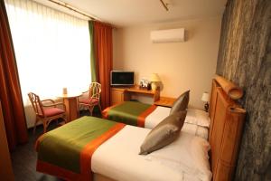 Wemmel玫瑰园酒店的酒店客房配有两张床和一张书桌