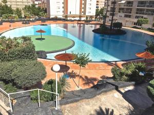 贝尼多姆Residence Vacanza Torre Monaco的城市里带遮阳伞的大型游泳池