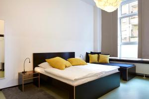 柏林胡腾帕拉斯特酒店的一间卧室配有一张带黄色枕头的床。