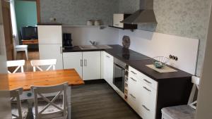 古梅尔斯巴赫历史公寓的厨房配有白色橱柜和木桌