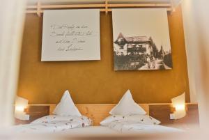 梅拉诺Hotel Villa Freiheim的墙上有两张照片的房间的两张床
