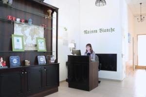 基辅Maison Blanche Kyiv city center的坐在商店柜台的手提电脑的女人