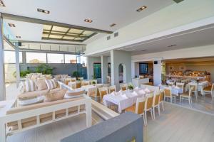 雅典Palace Hotel Glyfada的一间设有白色桌椅的用餐室