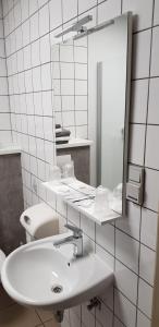 亨克维内酒店的白色的浴室设有水槽和镜子
